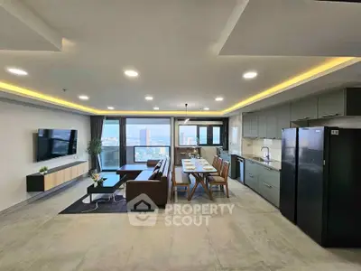 Spacious modern living room with open kitchen and stunning city view, perfect for urban living.