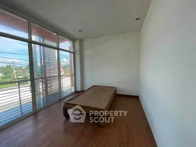 Spacious room with large windows and wooden flooring, ideal for customization.