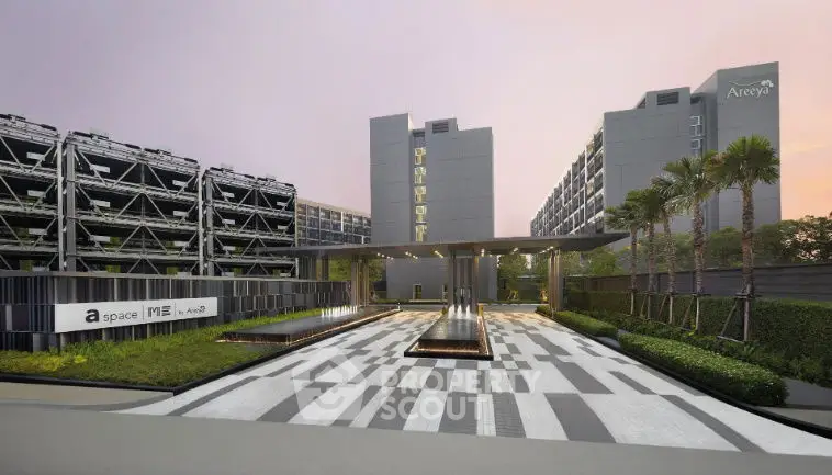 Modern apartment complex entrance with sleek design and lush greenery