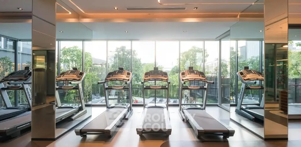 Modern gym with treadmills and large windows offering garden views