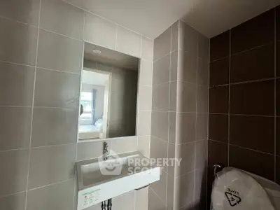 Modern bathroom with sleek sink and large mirror in contemporary apartment.