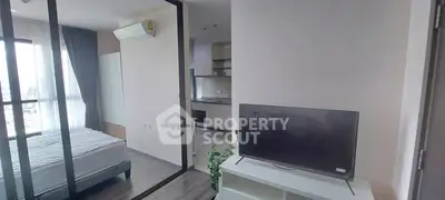 Modern apartment interior with bedroom and living area, featuring sleek design and natural light.
