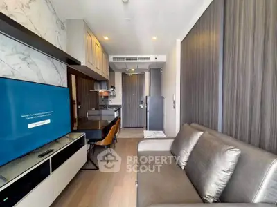 Modern living room with sleek design and open kitchen layout in a stylish apartment.