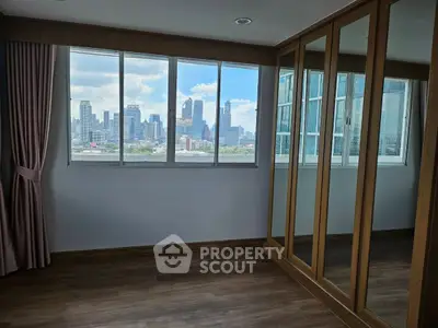 Spacious room with city view and large mirrored wardrobe, perfect for urban living.