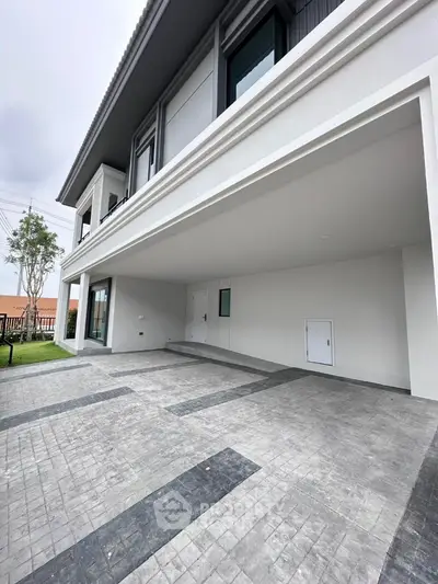 Modern residential building with spacious covered parking area and sleek architectural design.