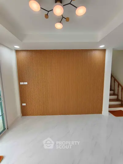 Modern interior with elegant wood paneling and stylish lighting in a spacious living area.