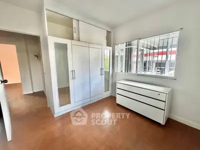 Spacious bedroom with built-in wardrobe and large window for natural light.