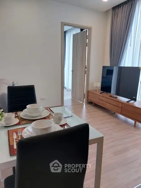 Modern living room with stylish furniture and dining setup, perfect for cozy gatherings.