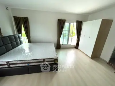 Spacious bedroom with large window and modern furnishings