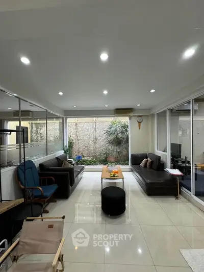 Spacious living room with modern furniture and large windows offering natural light.