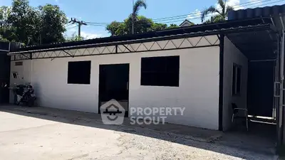 Charming single-story building with modern facade and ample parking space.