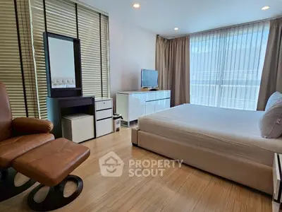 Spacious modern bedroom with elegant furnishings and natural light