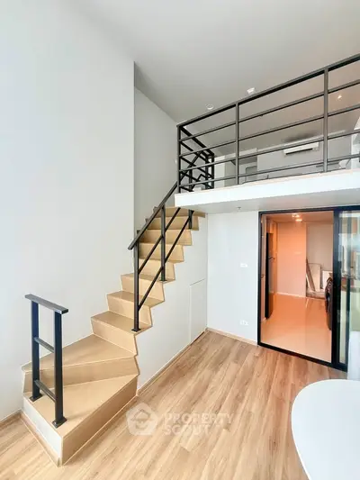 Modern loft apartment with stylish staircase and open layout, featuring sleek wooden flooring and contemporary design.