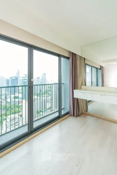 Spacious modern apartment with floor-to-ceiling windows offering stunning city views and abundant natural light.