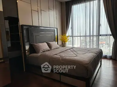Luxurious bedroom with large window offering stunning city views and elegant decor.