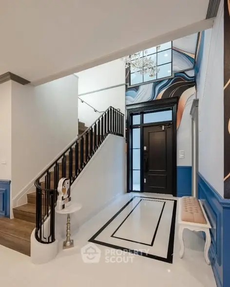 Elegant entrance with modern staircase and artistic wall design