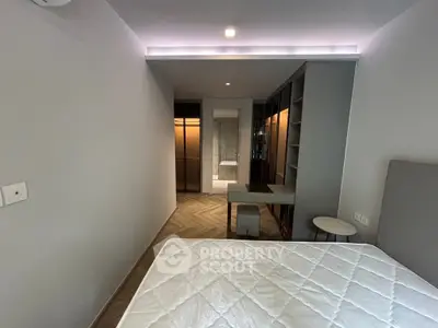 Modern bedroom with stylish decor and ensuite bathroom, featuring sleek furniture and ambient lighting.