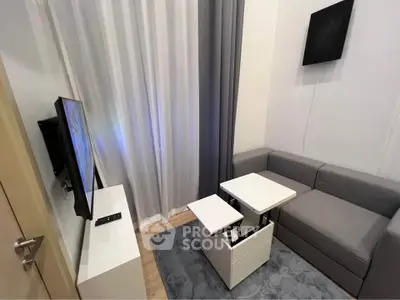 Modern compact living room with sleek furniture and wall-mounted TV, perfect for urban living.