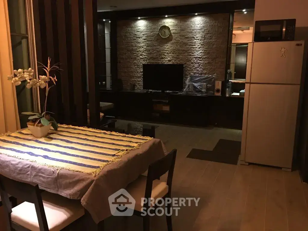 Cozy dining area with modern kitchen and stylish living room in open layout apartment.
