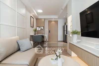 Modern living room with stylish decor and open kitchen layout, featuring a cozy sofa and wall-mounted TV.