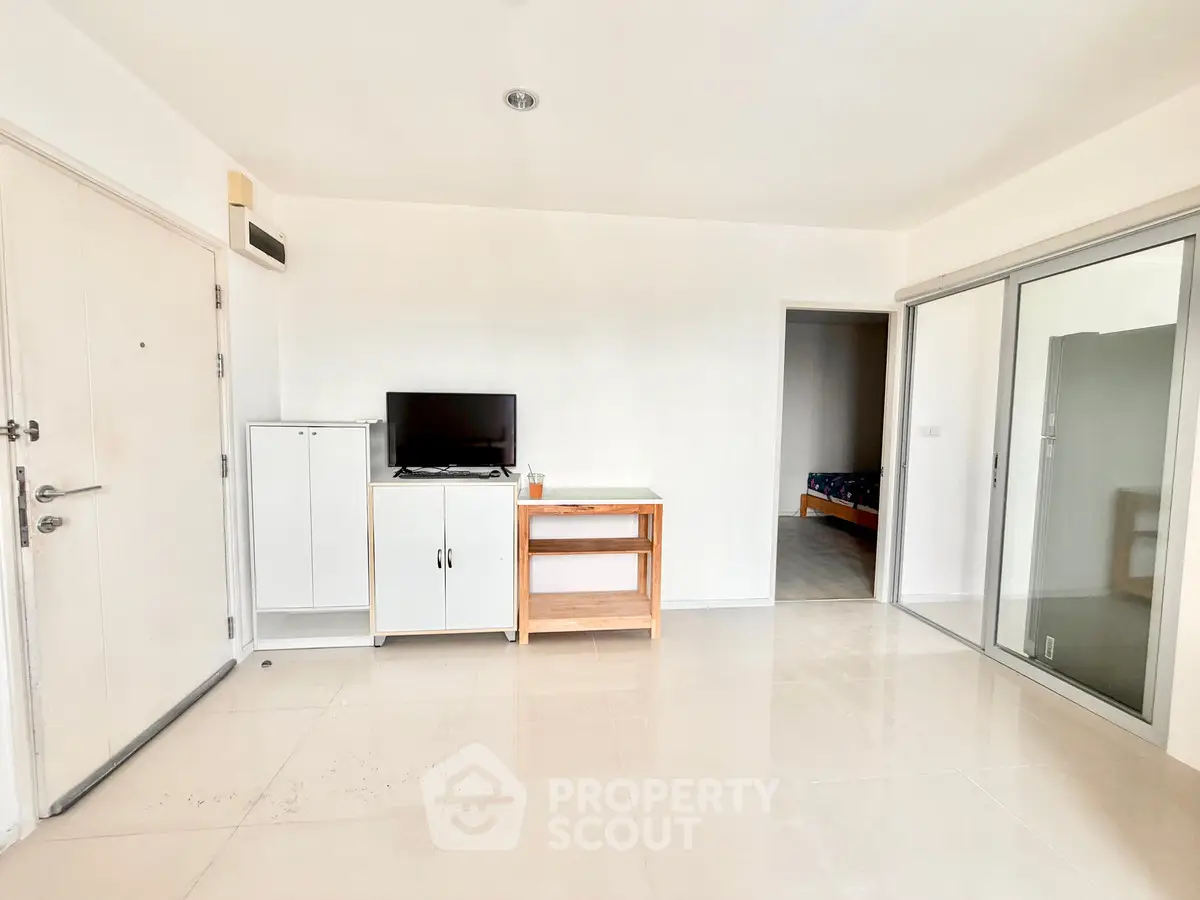Spacious minimalist living room with TV and sliding glass door