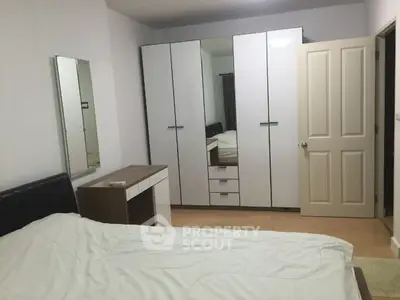 Spacious bedroom with modern wardrobe and cozy bed setup