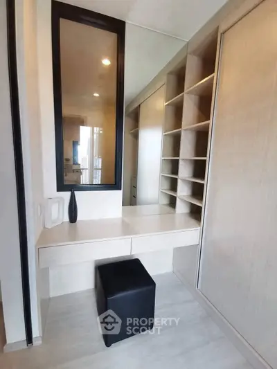 Spacious walk-in closet with modern shelving and seating in a stylish apartment.