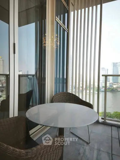 Stylish balcony with river view and modern seating in high-rise apartment