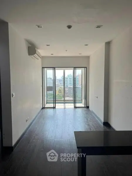Spacious modern living room with large windows and city view, perfect for urban living.