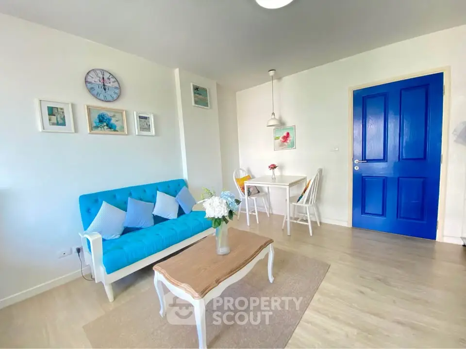 Charming living room with vibrant blue accents and cozy dining area