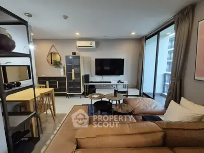Modern living room with stylish furniture and large balcony access in a contemporary apartment.