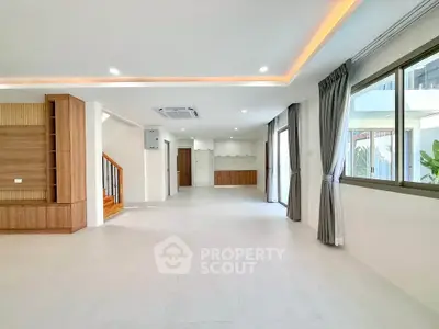 Spacious modern living room with large windows and elegant lighting