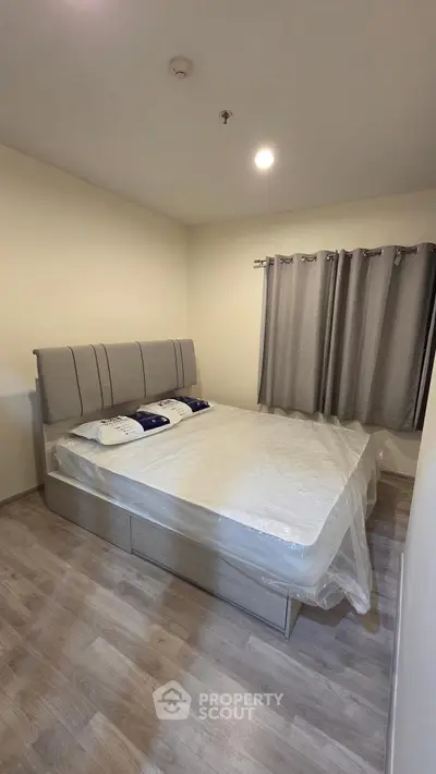 Spacious bedroom with modern bed and stylish curtains, perfect for restful nights.