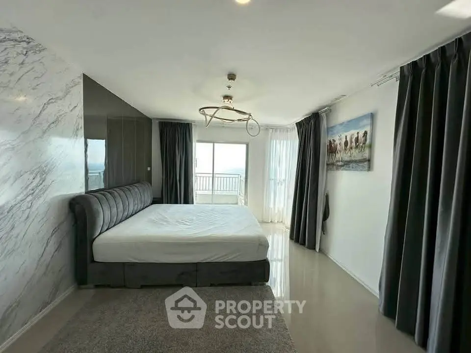 Spacious bedroom with modern decor and large windows offering natural light and scenic views.