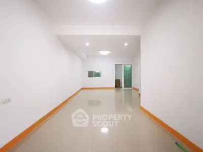 Spacious unfurnished room with glossy tiled floor and bright lighting