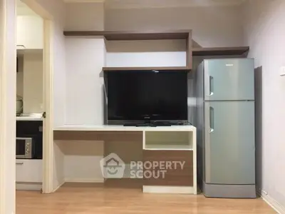 Modern living room with sleek TV unit and stainless steel fridge