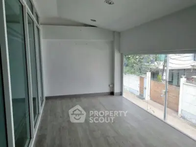 Spacious room with large windows and modern flooring, ideal for a bright living space.