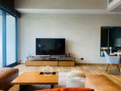 Modern living room with stylish furniture and large TV, featuring wooden flooring and contemporary decor.