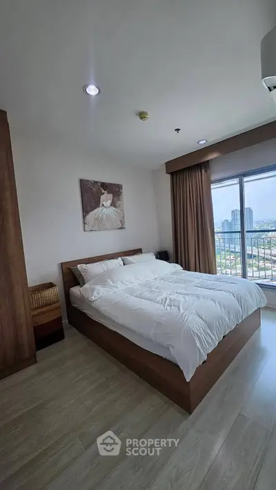 Modern bedroom with city view, featuring a cozy bed and elegant decor, perfect for urban living.