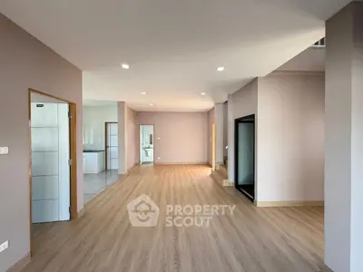 Spacious open-plan living area with modern wood flooring and ample natural light.
