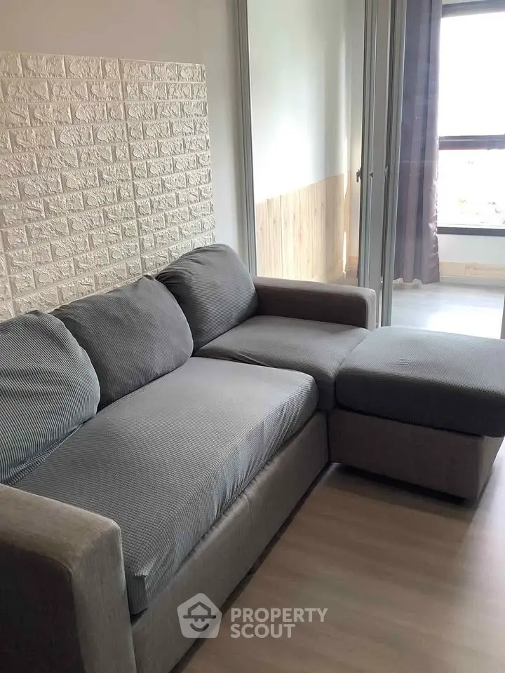 Modern living room with stylish gray sofa and natural light