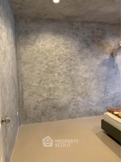 Minimalist bedroom with textured gray walls and simple decor