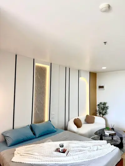 Modern bedroom with stylish decor and cozy seating area, perfect for relaxation and comfort.