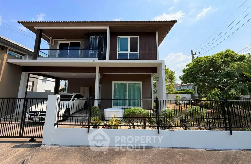 Modern two-story house with carport and landscaped front yard in a suburban neighborhood.