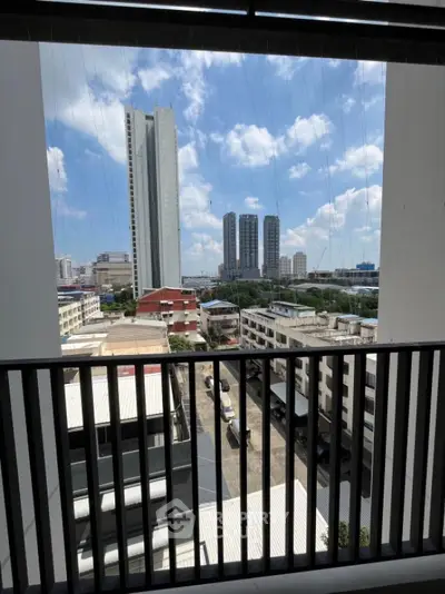 Stunning urban view from a high-rise balcony overlooking city skyline and modern architecture.