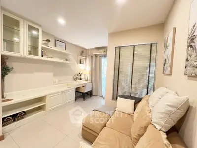 Cozy living room with beige sofa and built-in shelves, perfect for relaxation.
