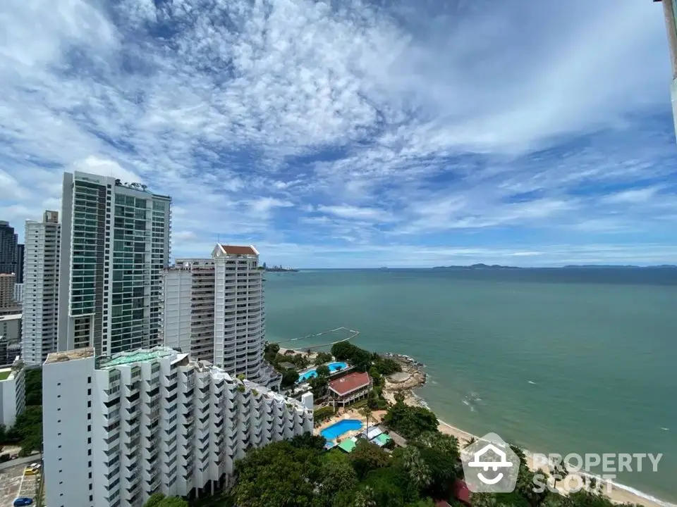 Stunning ocean view from high-rise apartment balcony with clear blue skies.