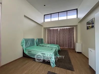Spacious bedroom with twin beds and large windows for natural light.