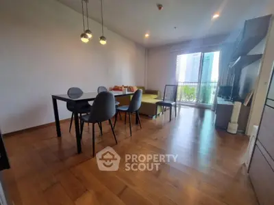 Spacious living room with modern dining area and balcony view in a stylish apartment.