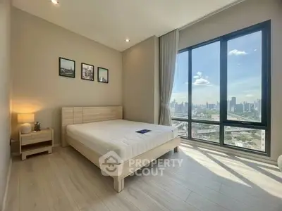Spacious bedroom with large window offering stunning city views, modern decor, and natural light.